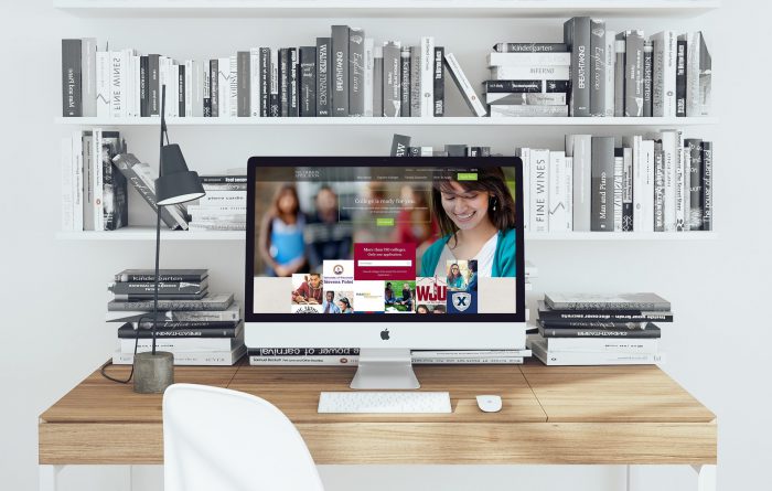 The common applications homepage is shown on a large desktop computer on a desk in front of shelves of black & white books